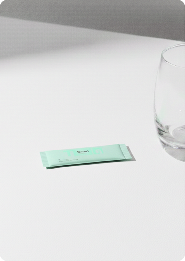 Light green hydration sachet labeled “Boost” placed on a white surface beside a clear empty glass.