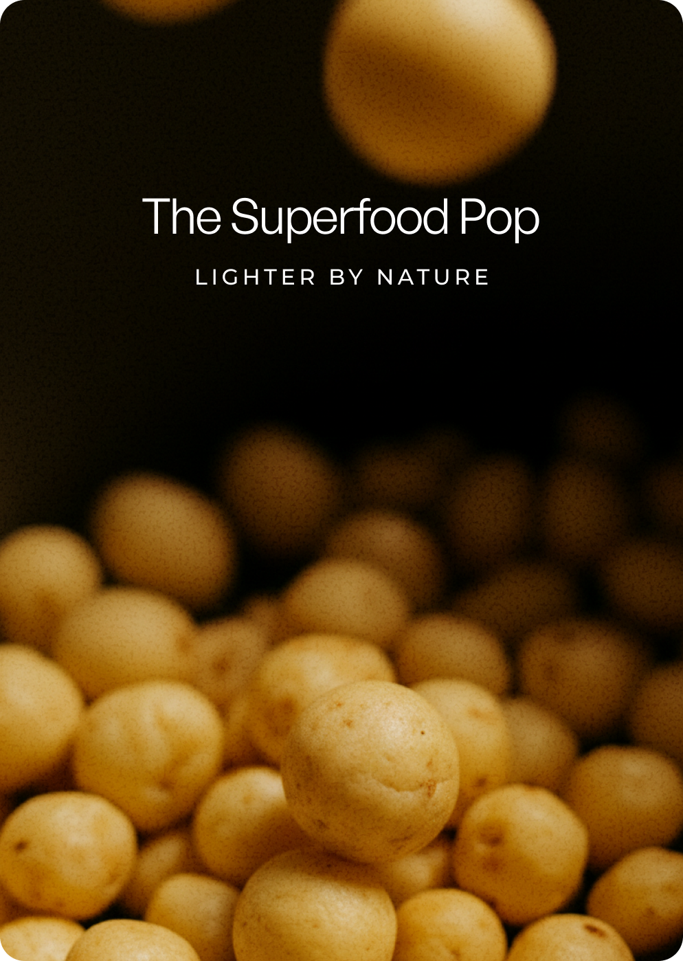 Close-up of round, air-popped lotus seed snacks in warm light, with a shallow depth of field and soft background blur.